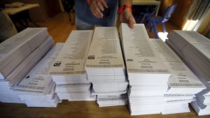 Una persona escull entre diferents llistes electorals abans de votar.