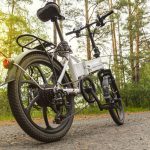 electric bike on an asphalt track in the forest without people. concept of healthy walking and riding outdoors in the park. Bicycle on the background of a pine summer forest.