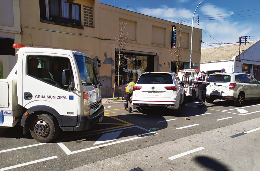 Grua recollint cotxes aparcats al carril bici del carrer Balmes d'Igualada.